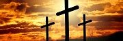 3 crosses on a hill as the sun sets behind them