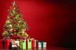 A conversation with Jesus on Christmas - about the decorated tree with the presents under it, set in a room with red walls.
